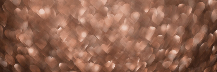 Mocha Mousse, brown sparkling glitter hearts bokeh background banner, abstract defocused texture header. Holiday lights.