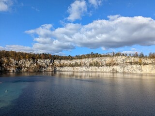 Crystal Clear Lake Surrounded by Rocky Cliffs and Autumn Trees