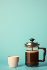 Coffee maker beside minimalist cup on vibrant blue background, i