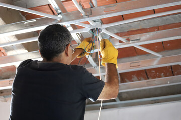 Electrician working on the light wiring of a home