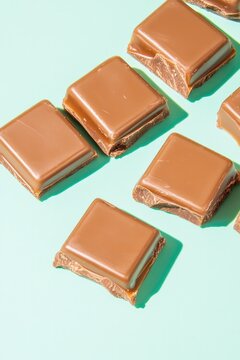 Chocolate squares arranged on mint background create fresh, enti
