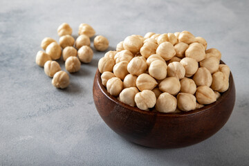 Top view of a bowl full of peeled hazelnuts kernel on concrete background,top view
