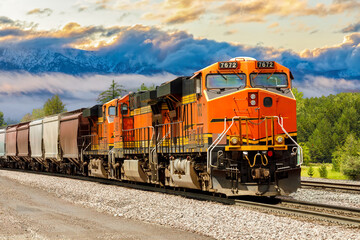 freight train hauling cargo in northwest Montana with a scenic background