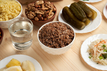 Lenten dishes against a wooden background remind of the light of a post that illuminates the path to God through prayer and abstinence.