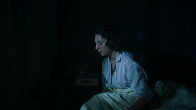 Young woman walking up at night and sleepwalking with her eyes closed around bedroom