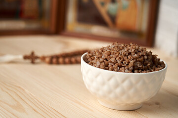 Boiled buckwheat is simplicity and modesty .Buckwheat on a wooden background symbolizes simplicity and modesty, which help believers focus on spiritual life during Lent