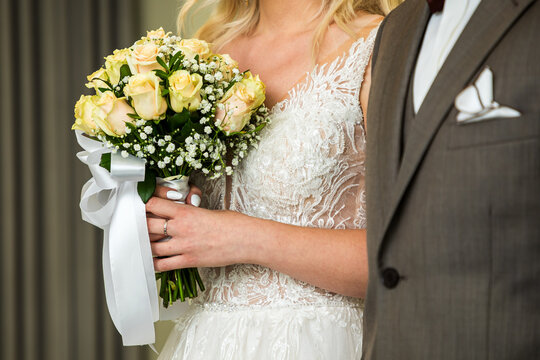 Macro view of bouquet of flowers holding by obscured bride on wedding