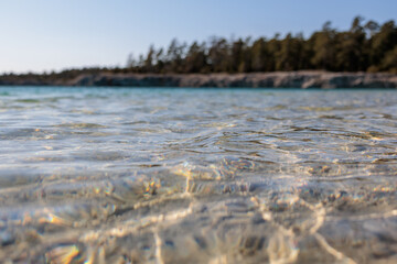 close up of crystal clear water in limestone lake on Gotland on a sunny springtime afternoon