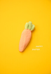 Soft-textured marshmallow carrot with green leaves on a bright yellow background. Ideal for festive decor, cards, and branding.