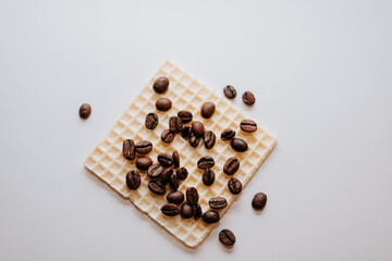 A beautiful combination of a waffle and coffee beans on a white background.