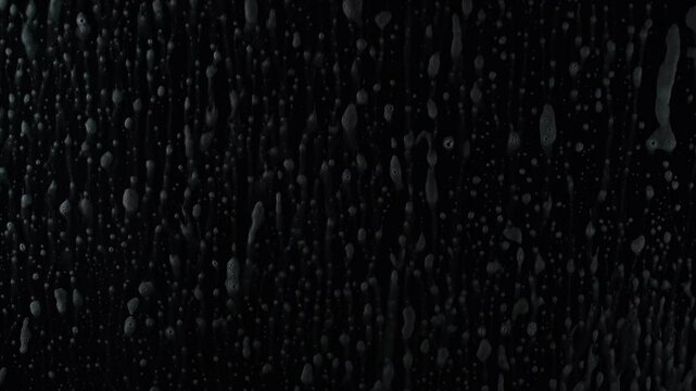 Soapy spray and squeegee cleaning glass, isolated on black. Enjoy foamy swirls and spotless results, ideal for commercials or tutorials on pristine surfaces. Satisfying visuals highlight clarity.