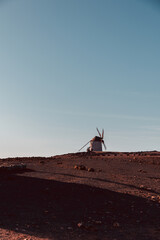 View of the old, typical windmills of Villaverde, Fuerteventura, Canary Islands, with their wooden blades. almost sunset, oblique light, golden hour. Past, vintage feeling.