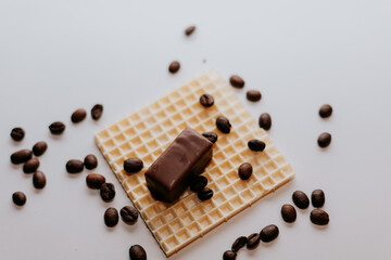 Chocolate, coffee beans, and a waffle on a white background.