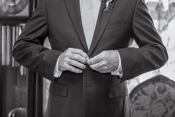 man in tuxedo buttoning jacket