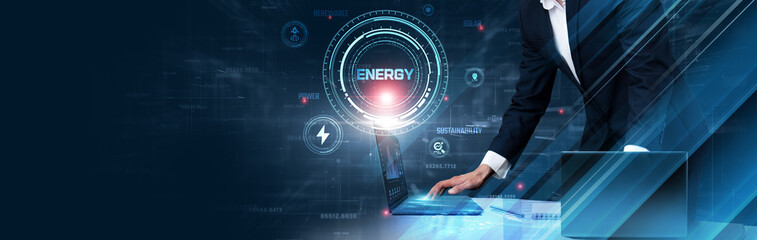 Energy Technology: Businessman uses laptop and synchronizes data of energy systems on computer device with global network, renewable sources, smart grids, energy efficiency, sustainability
