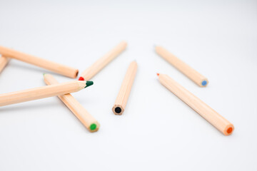 Colorful wooden pencils scattered on white background