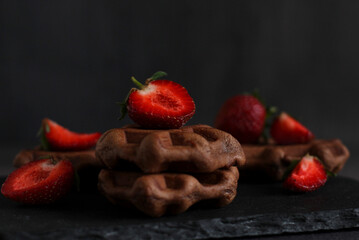 dessert pastry chocolate waffles with strawberries on a dark background