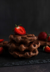 dessert pastry chocolate waffles with strawberries on a dark background