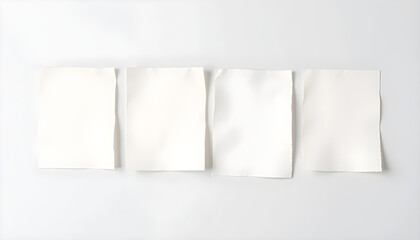 Four blank white sheets of paper aligned in a row with slight curls, creating depth