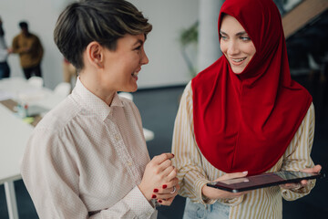 Businesswomen using tablet and discussing in modern office