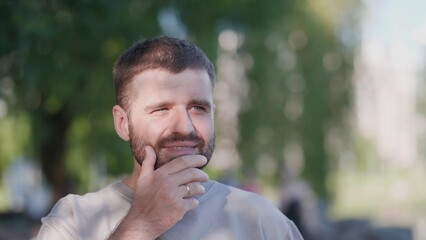 A thoughtful bearded man, immersed in contemplation, finds himself encompassed by the splendid beauty of vibrant nature