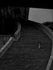 A person goes up a large stair. 