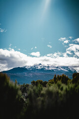 Mount Kilimanjaro surrounded by grassy plains an sun rays