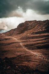 A trail of hikers in the desert on the path to Mount Kilimanjaro in Tanzania Africa