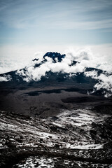 A mountain peak covered in clouds as seen from Uhuru Peak of Mount Kilimanjaro in Tanzania Africa