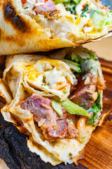 Delicious meat wrap featuring fresh ingredients on a wooden platter