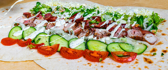 Delicious wrap preparation with fresh ingredients and grilled meat