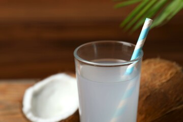 Glass with coconut water with nuts on wooden table