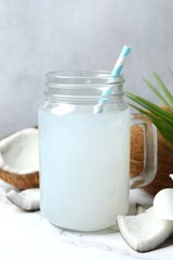 Mason jar with coconut water with nuts on wooden table