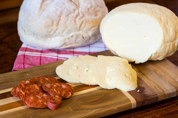 Traditional Eastern European Homemade Cheese (Hrudka) Served on Wooden Board with Sausage