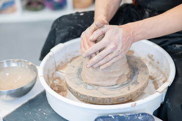 The potter kneads the clay before using it on the potter's wheel. Close-up of a man's hands. 