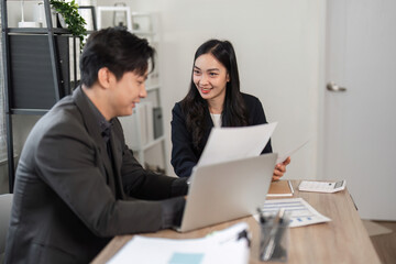 Obraz premium Team members analyzing financial reports together in a contemporary office space.