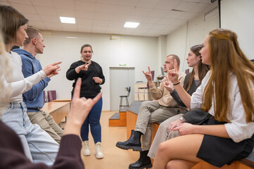 Young people communicate in sign language in a university classroom. 