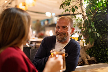 happy couple enjoying coffee and tea at bar at night