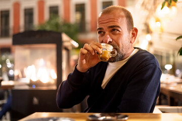 young man enjoying coffee at night in a bar