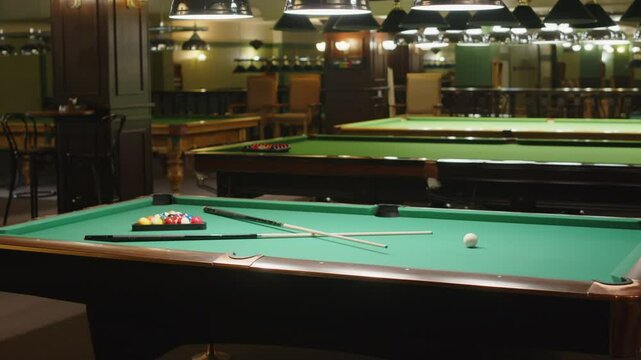 No people shot of green billiard table with cues and balls prepared for pool game in modern bar