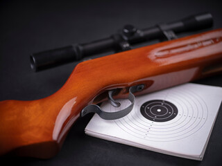 Air gun, shield and goggles on a dark background.