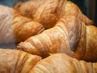 Freshly baked croissants display in a pastry case at a bakery