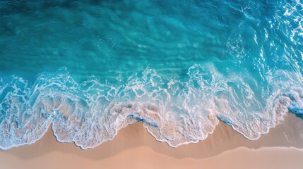 Obraz premium Drone shot of a beautiful tropical beach. The clear blue sea sparkles under the sun, waves gently rolling onto the sandy shore. A perfect scene