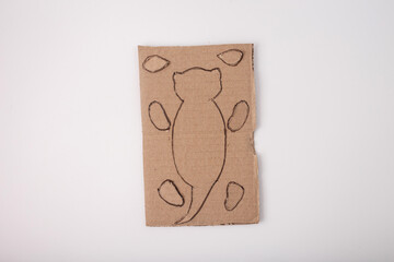 a piece of cardboard with outlines otter drawn on it. cardboard have been cut, a template or...