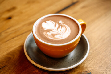 Cup of cocoa with milk art on wooden table in the morning at breakfast
