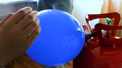 Teenage girl inflating a blue balloon with a helium tank at home, preparing decor for a party, festive event or birthday celebration. 4k Video
