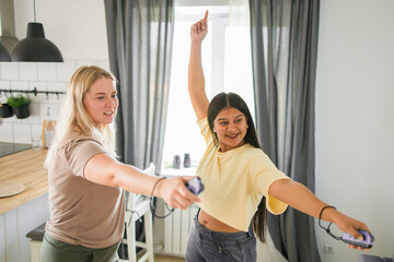 Fototapeta premium Cheerful group of friends playing video games together at home, leisure and entertainment concept