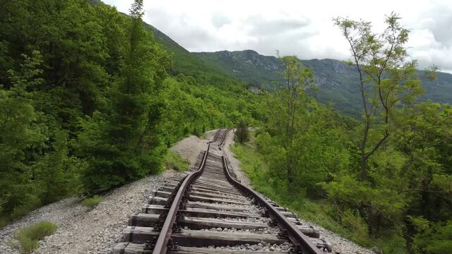 POV first person view of Pijana pruga or drunk railway in Istria, Croatia. A stretch of neglected railway track and bed, deformed rails, washed down by land slide or poor earth base