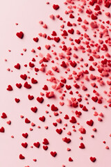 A playful digital pattern of tiny red hearts scattered across a light pink background, giving it a charming and romantic aesthetic.