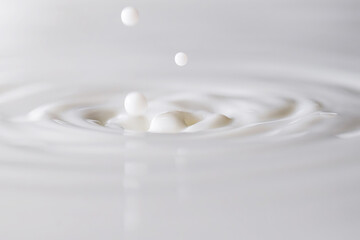 Milk white liquid splashing and making droplets